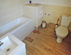 Ein Badezimmer mit Badewanne, Toilette und Waschbecken.
