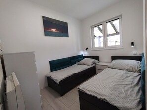 Cozy retreat with a single bed, bedside table, and lamp, plus a wall-mounted artwork.