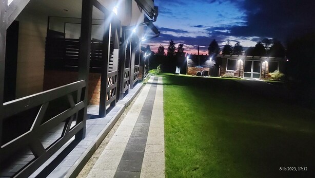 Un bâtiment doté d’un espace extérieur abrité, d’un chemin pavé et d’une pelouse bien entretenue.