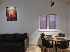 Cozy living space with a sofa, dining table, and window.