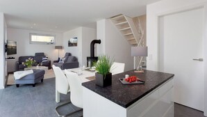 Un appartement moderne doté d’un îlot de cuisine, d’un coin repas et d’un salon.