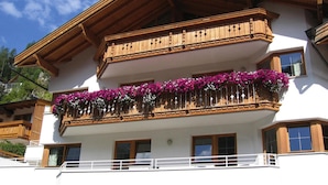 A multi-story building with wooden balconies and flower boxes.