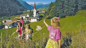 A rural village with a church, houses, and a clear sky.