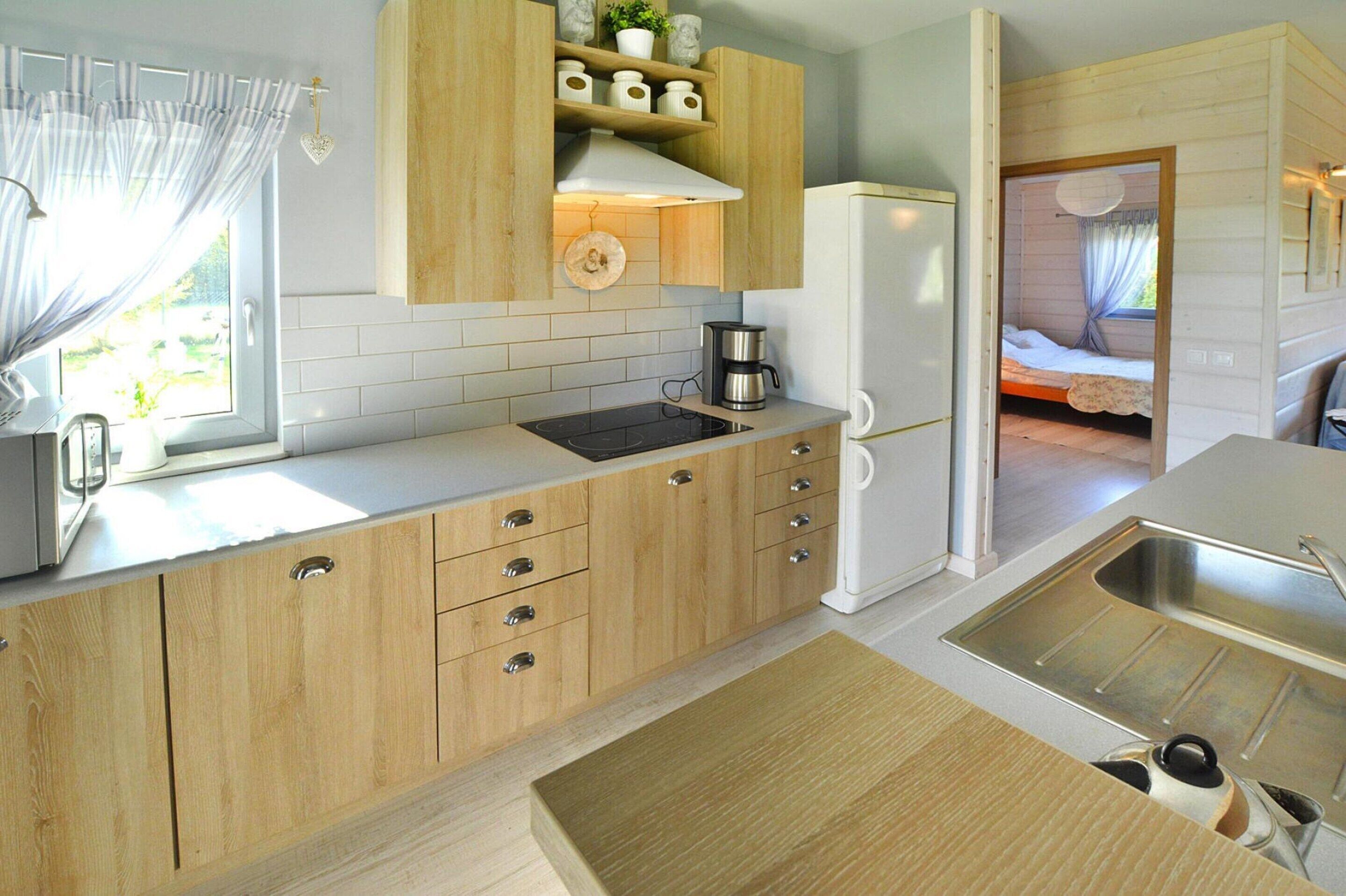 A compact kitchen with wooden cabinets, a built-in stove, and a refrigerator.