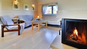 Un salon chaleureux avec une cheminée, des murs en bois et un canapé.