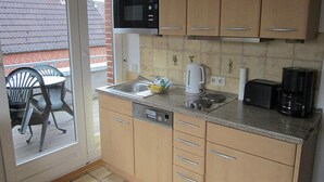 Een kleine keuken met een magnetron, broodrooster en koffiezetapparaat.