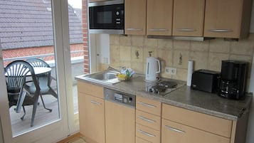 Uma cozinha compacta com micro-ondas, torradeira e cafeteira.
