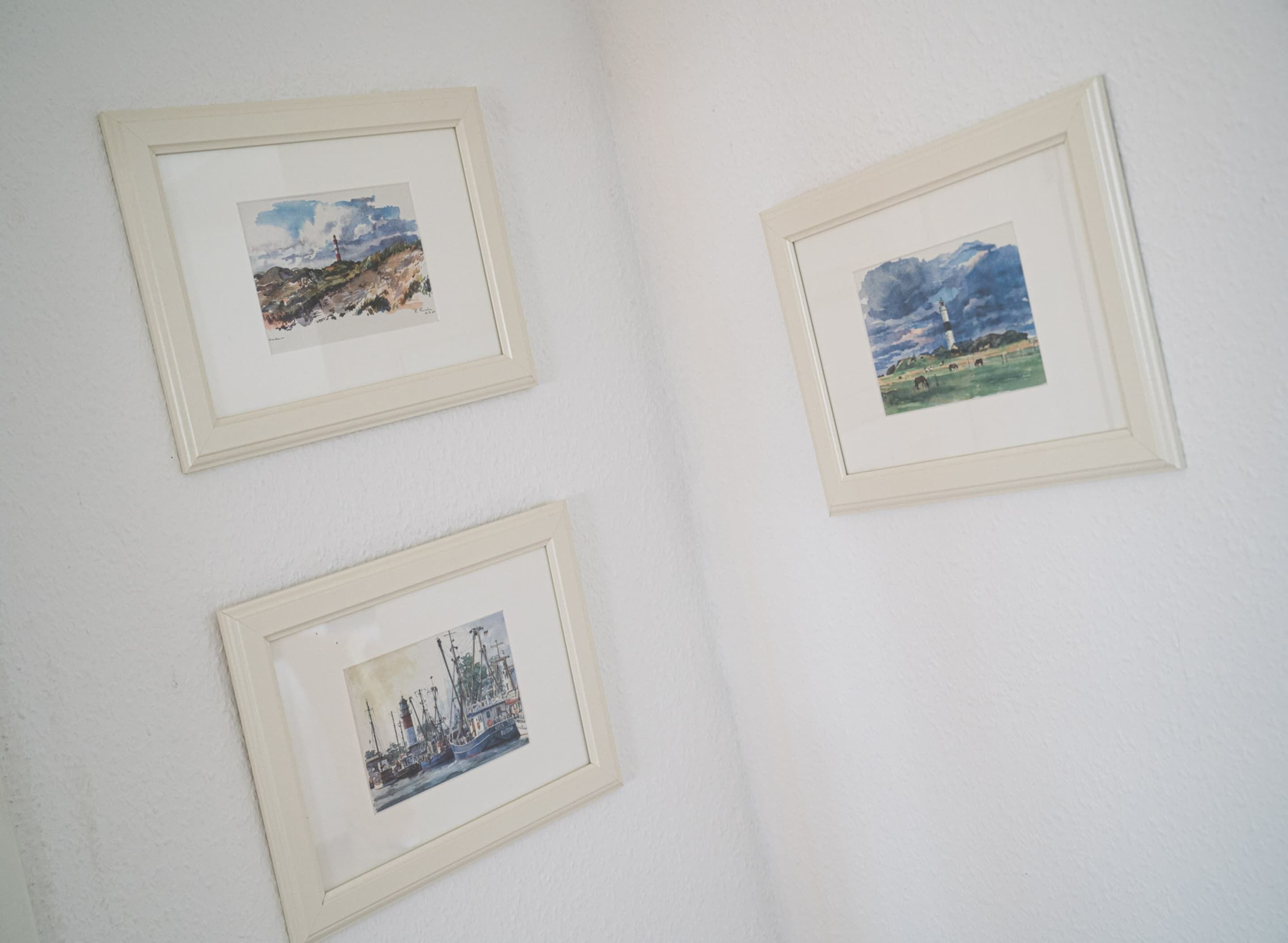 Tres obras de arte enmarcadas en una pared.