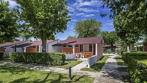 A row of modern, single-story mobile homes with a paved walkway and manicured lawns. - Bungalow in Caorle With Garden Furniture (Caorle)