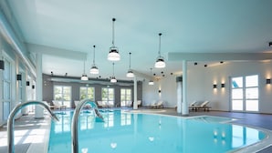 An indoor swimming pool with clear water, surrounded by lounge chairs and a tiled floor. - Apartment in Dranske With Pool (Dranske)