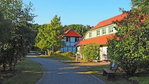 A rural road leading to a traditional house with a red roof and white walls. - Apartment in Dranske With Pool (Dranske)
