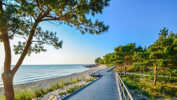 A wooden boardwalk leading to a beach with a clear view of the sea. - Comfortable, 2-person Holiday Studio (Ustronie Morskie)
