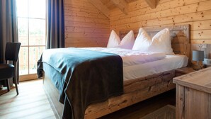 Un dormitorio de cabaña de madera con una cama, una silla y un escritorio.