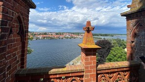A brick structure with a view of a river and a town in the background. - Ferienwohnungen, Malchow (Malchow)