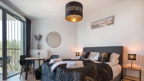 Een moderne slaapkamer met een groot bed, een bureau en een stoel.