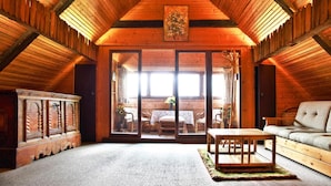 A log cabin interior with a high ceiling, wooden walls, a dining area with a table and chairs, and a sofa. - Farmhouse Near Afritzer See & Nockberge Trails (Treffen)