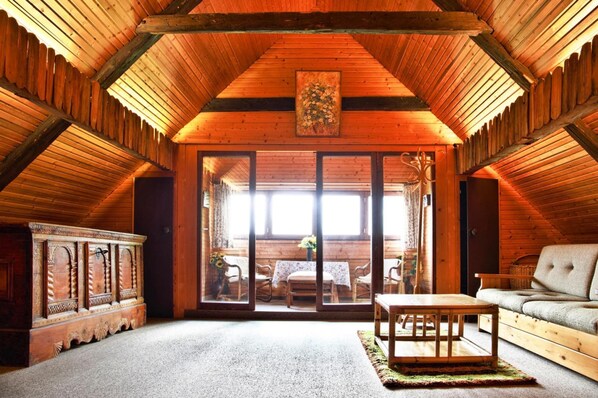 A log cabin interior with a high ceiling, wooden walls, a dining area with a table and chairs, and a sofa. - Farmhouse Near Afritzer See & Nockberge Trails (Treffen)