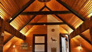 A wooden attic bedroom with a sloped ceiling, a wooden door, and a small window. - Farmhouse Near Afritzer See & Nockberge Trails (Treffen)