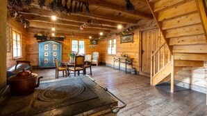 Un interior rústico de madera con cocina, paredes de madera y una escalera.