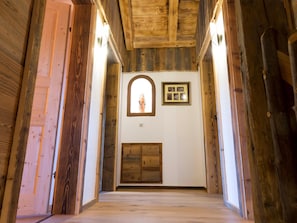 Ein Korridor mit Holzwänden und einer Holztür am Ende.
