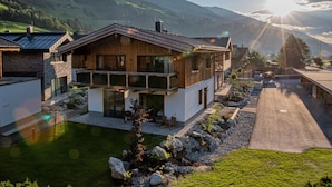 Une maison moderne à deux étages, dotée d’un grand balcon, d’une piscine et offrant une vue sur les montagnes.