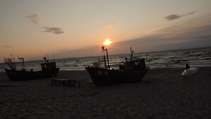 Two boats on a beach at sunset. - Holiday Home in Miedzyzdroje Near Baltic Sea (Międzyzdroje)