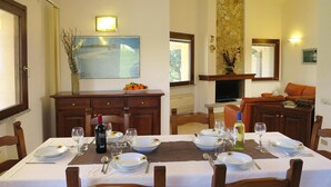 Un coin repas avec une table dressée pour deux personnes, un téléviseur et une cheminée.