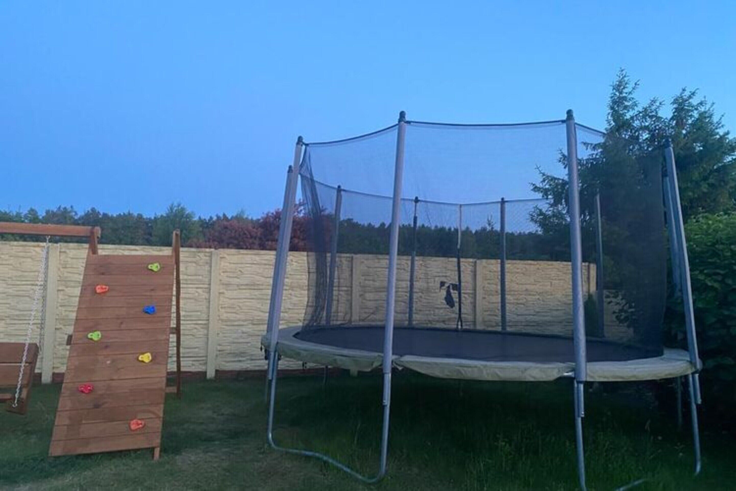 Ein Trampolin mit Sicherheitsnetz im Garten.