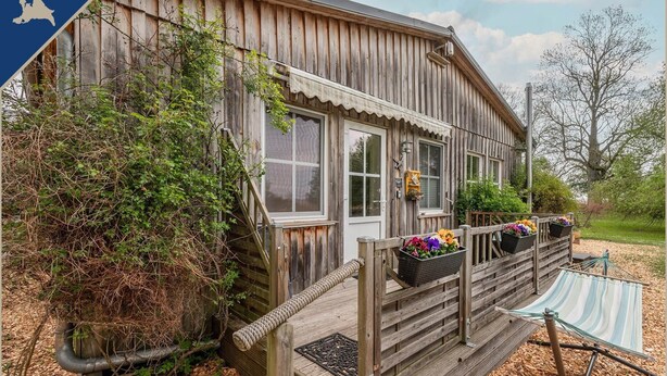 A wooden cabin with a porch, a small deck, and a hammock. - Ferienwohnung am Achterwasser in Lutow (Luetow)