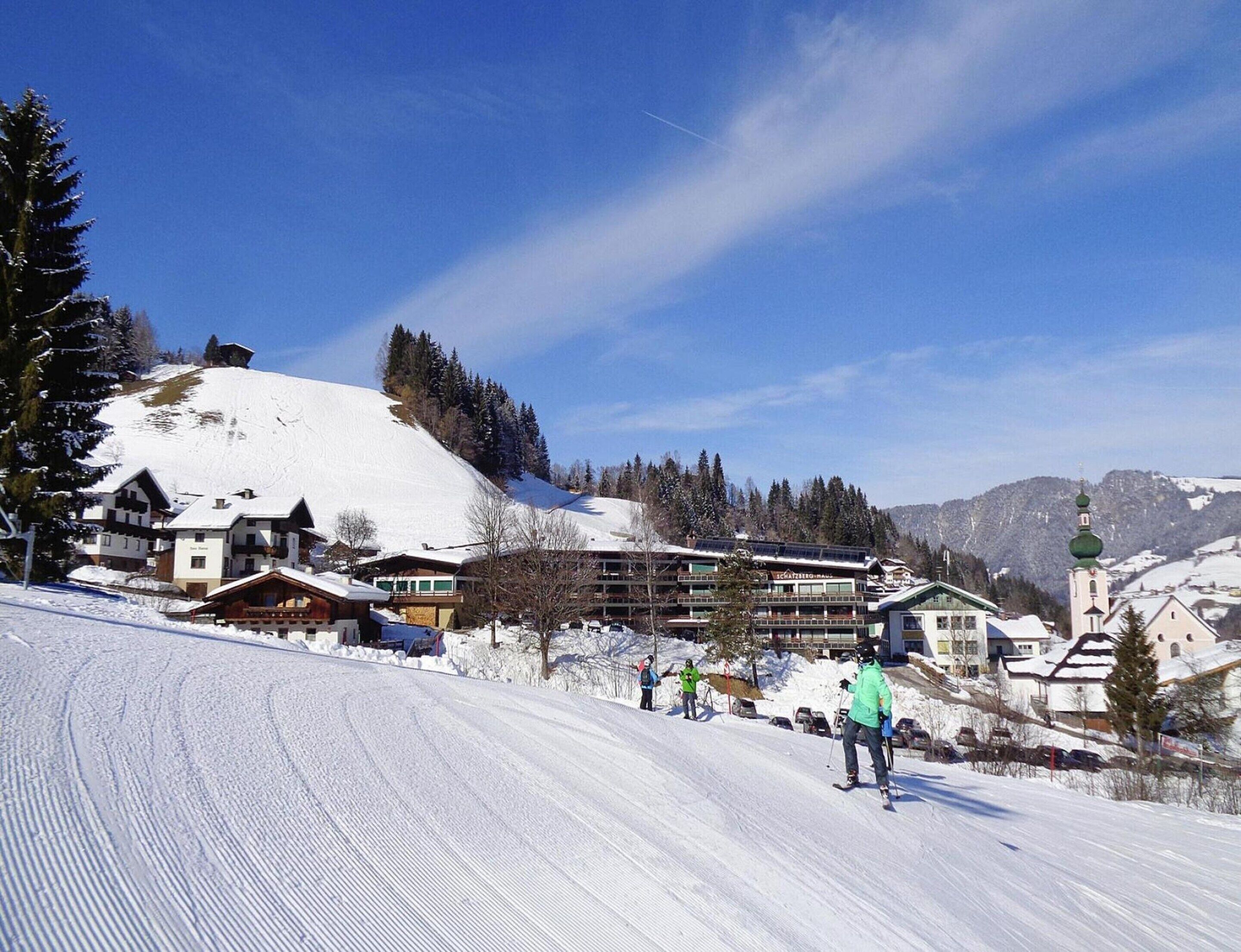 A ski resort with buildings, a ski slope, and a mountain backdrop.