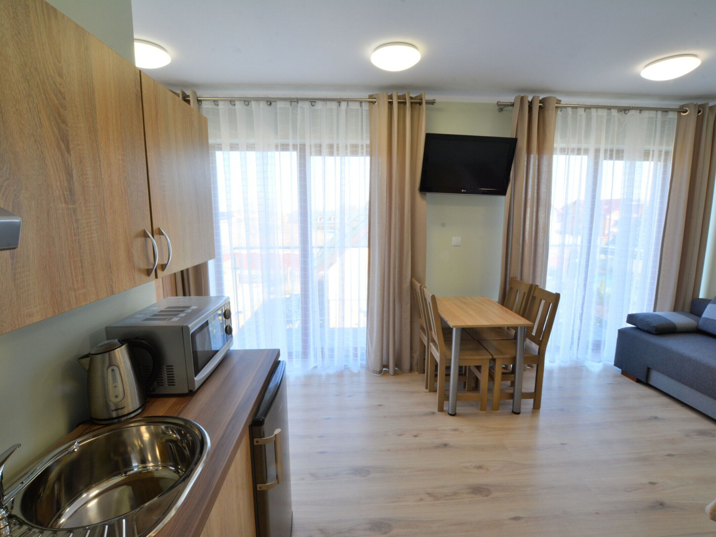 A compact living space with a kitchenette, a dining area, and a seating area.