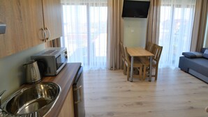 A compact living space with a kitchenette, a dining area, and a seating area. - Holiday Studio Near the Beach, Sarbinowo (Mielno)