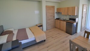 A compact room with a bed, a small kitchenette, and a dining area. - Holiday Studio Near the Beach, Sarbinowo (Mielno)
