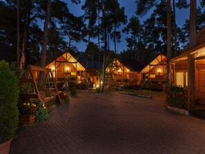 A wooden cabin-style lodging area with multiple cabins, paved pathways, and outdoor seating areas. - Holiday Homes Near the Seaside Beach, Pobierowo (Rewal)
