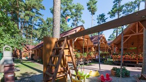 A wooden swing set and a ladder in a wooded area with a wooden cabin in the background. - Holiday Homes Near the Seaside Beach, Pobierowo (Rewal)