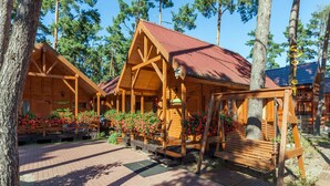 A wooden cabin with a red roof, surrounded by trees. - Holiday Homes Near the Seaside Beach, Pobierowo (Rewal)