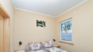 A bedroom with a bed, a window, a radiator, and a door. - Wohnung in Lubben an der Spree fur 4 Personen (Lübben (Spreewald))