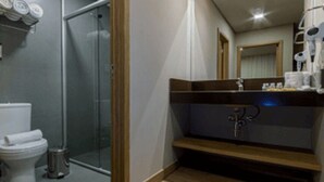 A modern bathroom with a glass shower, a toilet, and a sink with a mirror above it. - Golden Gramado Resort (Gramado)