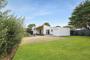 A single-story house with a front porch, a small deck, and a well-maintained lawn. - Back Beach Portsea: 4  BR, 2.5  BA House in Portsea, Sleeps 7 (Portsea)