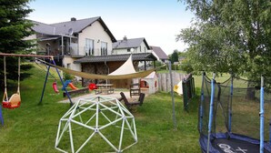 A backyard with a swing set, a trampoline, and a geodesic dome structure. - Ferienwohnung, Zemitz (Zemitz)