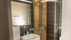 A modern bathroom with a glass-enclosed shower, a white sink, and a large mirror. - Holiday Apartment Right on the Beach, Pobierowo (Rewal)
