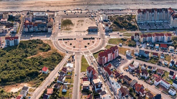 An aerial view of a coastal town with a central roundabout, residential buildings, and a beach. - Ferienwohnungen, Wyk auf Fohr (Wyk auf Foehr)