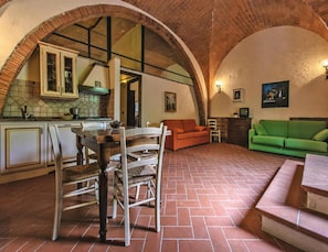 A spacious living area with a dining table, chairs, a sofa, and a green couch. - Apartment in Santo Pietro Belvedere With Pool-formerly TUI Ferienhaus (Capannoli)