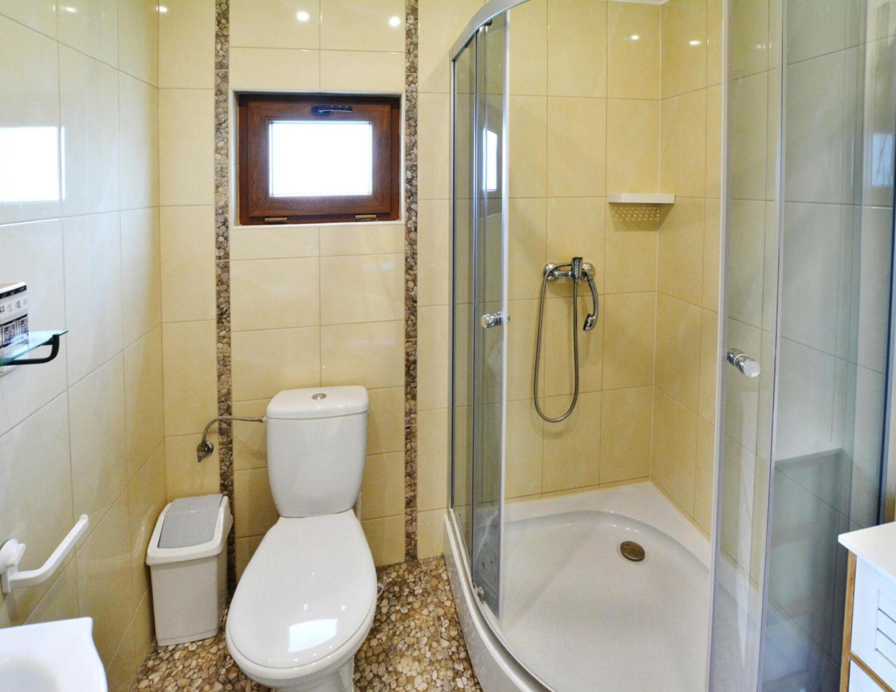 A bathroom with a toilet, a shower, and a sink.