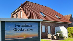 Un edificio con techo de tejas rojas y un letrero que dice 'Ferienhaus Glückstrefter'.