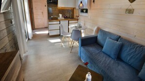 Ein gemütliches Blockhaus-Interieur mit Essbereich, Küchenzeile und einer Couch.