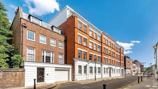 A row of terraced houses with a clear road in front.