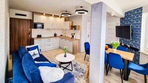 A modern apartment with a living room, kitchen, and dining area. - Unique Apartment With a Balcony in Darlowko (Darlowo)
