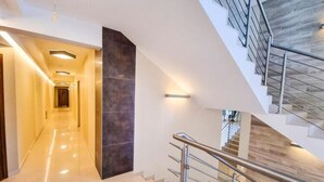 A modern hotel interior with a central hallway, a staircase with metal railings, and a dark accent wall. - Unique Apartment With a Balcony in Darlowko (Darlowo)