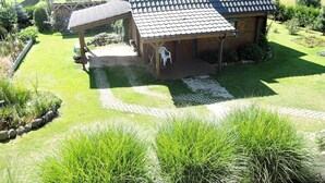 A rustic cabin with a tiled roof, a covered porch, and a stone pathway leading to the entrance. - Holiday Home in Kolczewo for Nature Lovers (gmina Wolin)